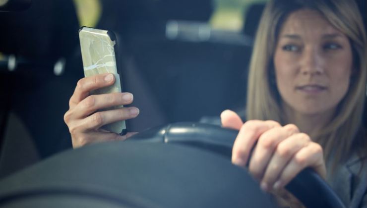 donna al volante con il cellulare in mano