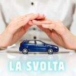 Una persona seduca copre con le mani una macchinina, in basso la scritta "la svolta"