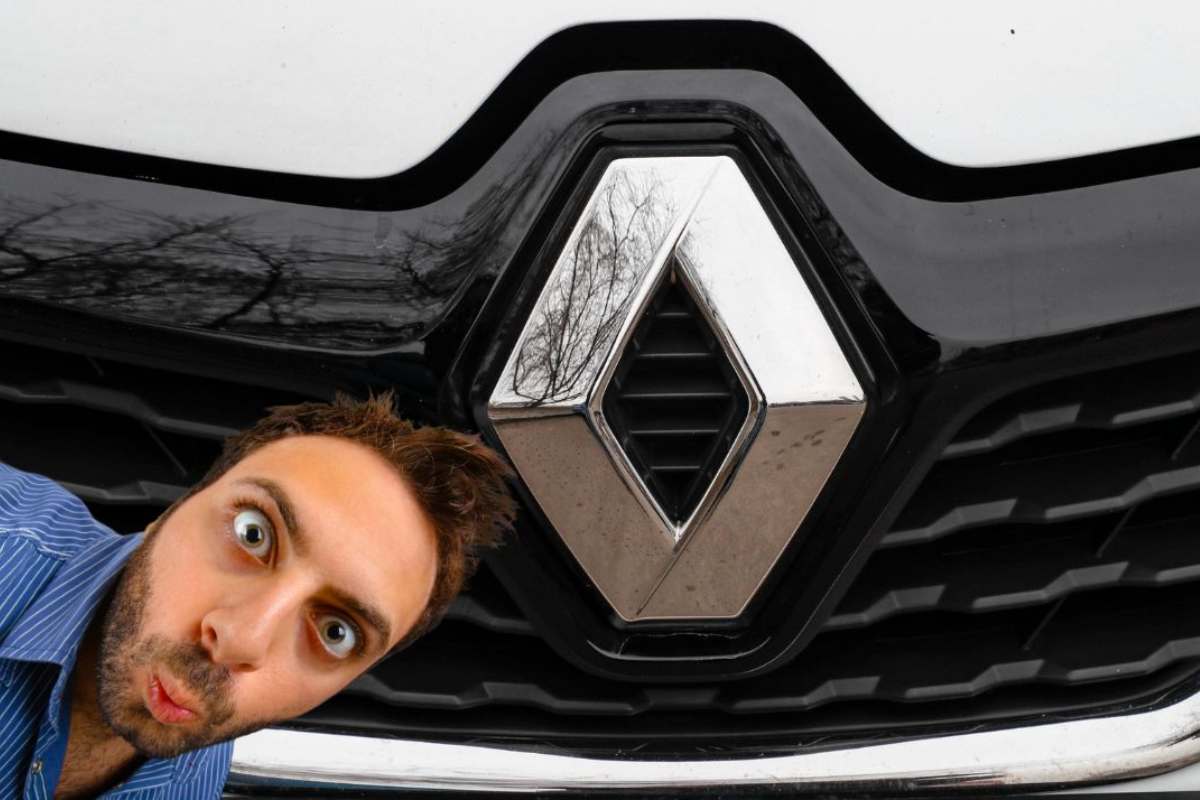 Il frontale di una Renault con il logo e a sinistra un uomo meravigliato