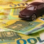 Modellino di auto su banconote da 100 euro