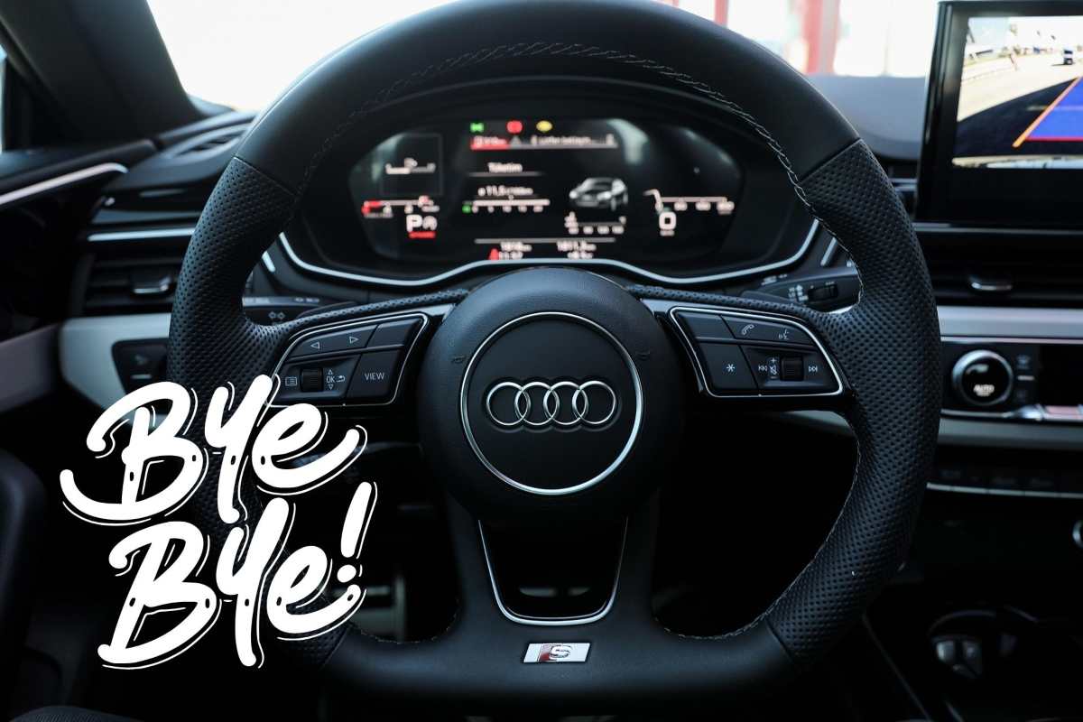 L'abitacolo di una Audi con il logo sul volante e la scritta Bye-Bye