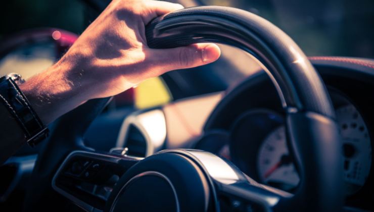 una persona con le mani sul volante