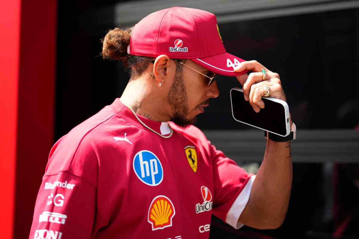 Lewis Hamilton si aggiusta il berretto nel box Ferrari