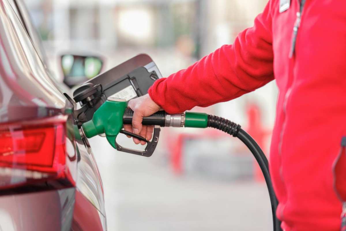 Un persona fa benzina al distributore