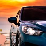 Un'auto al tramonto e un salvadanaio con degli euro in monete