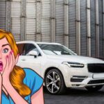 Un'auto bianca sullo sfondo e davanti il disegno di una donna meravigliata