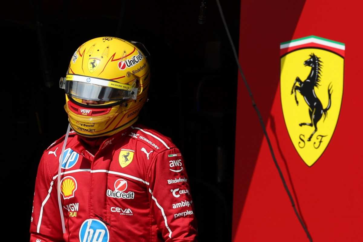 Hamilton con la tuta Ferrari nei box