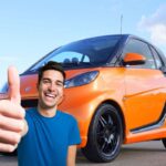 Una Smart e un ragazzo con il pollice in su